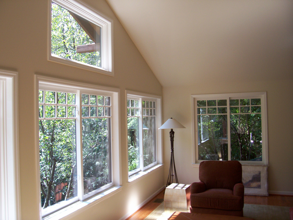 Sunlit room with windows, armchair, floor lamp