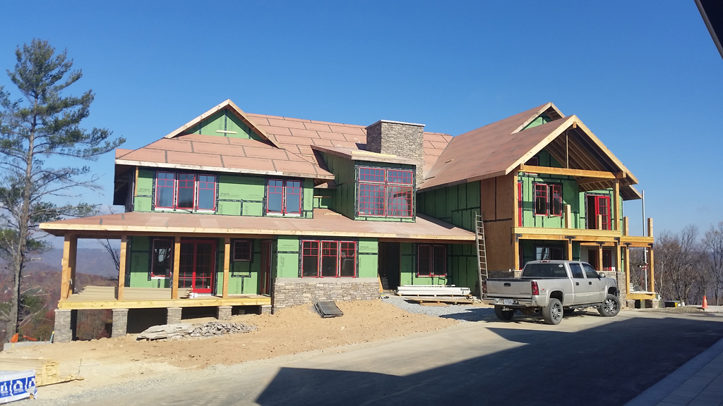 Large two-story house under construction with pickup truck