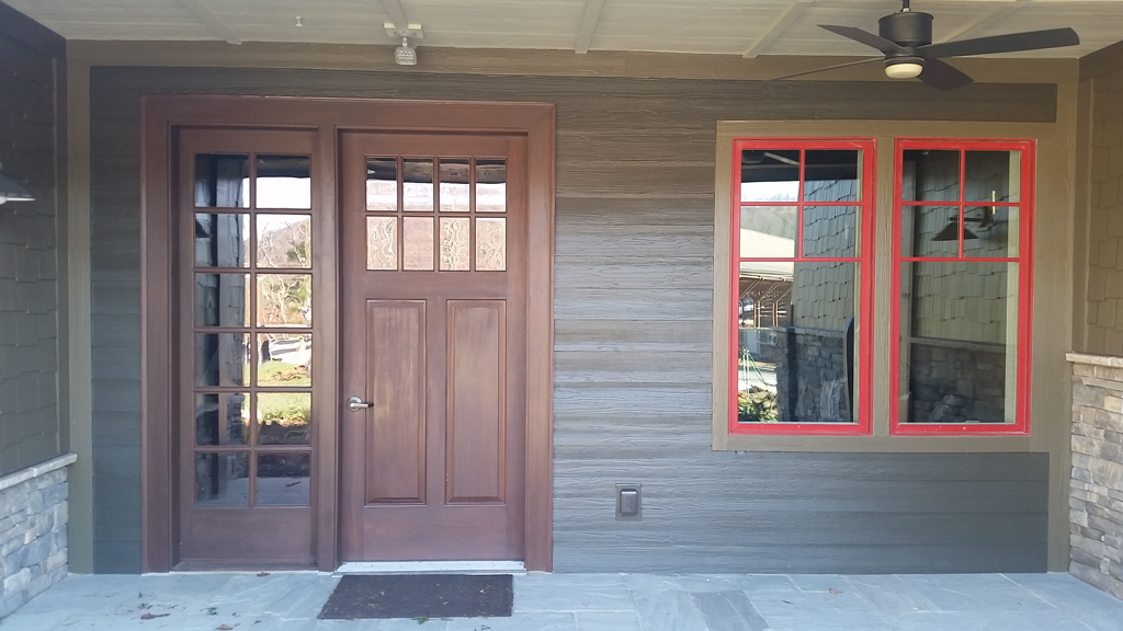 Wooden front door with red-trimmed window