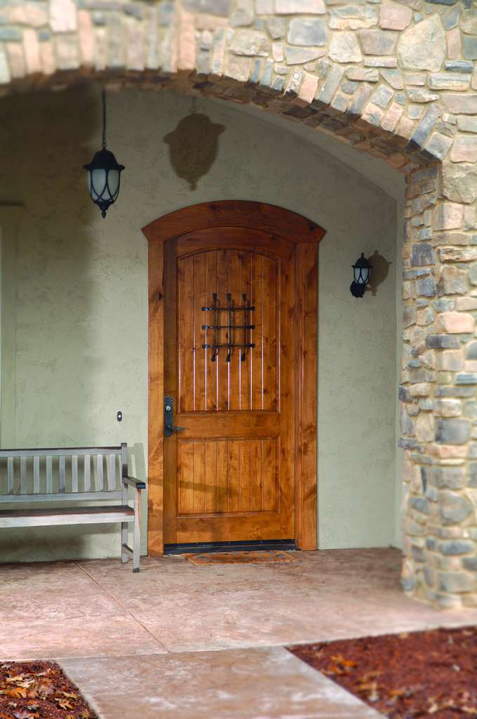 Arched wooden front door with stone archway