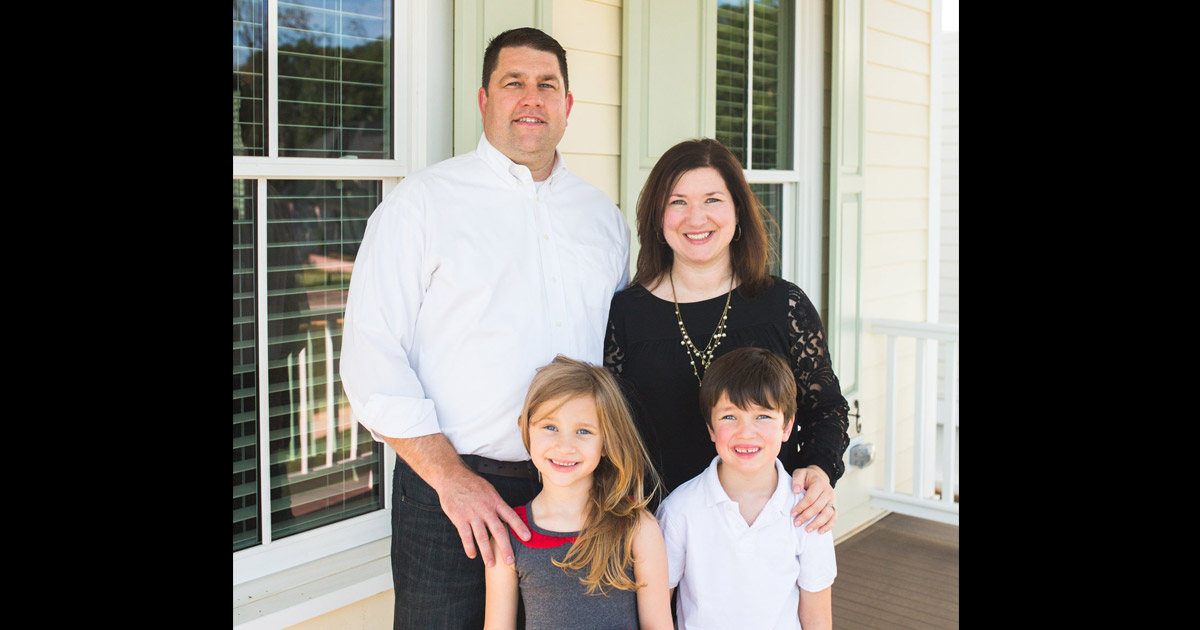 Smiling family of four on porch