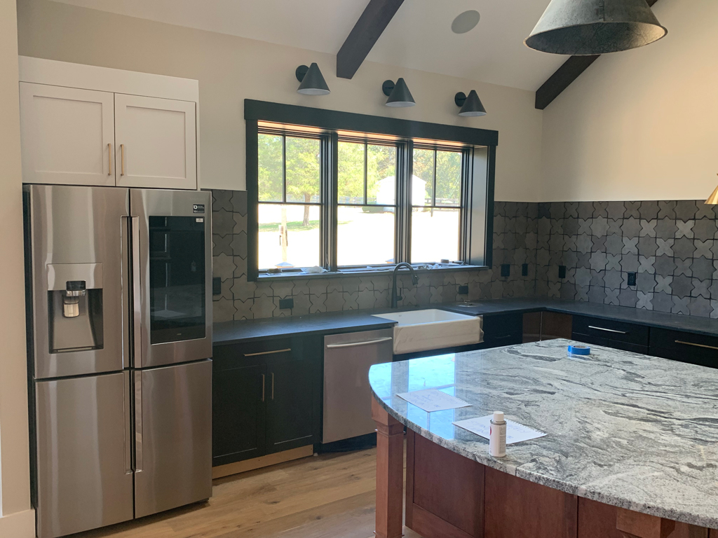 Modern kitchen with granite island and stainless refrigerator