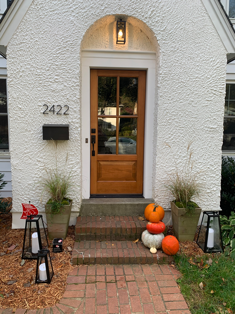 Wooden front door with pumpkins and lanterns