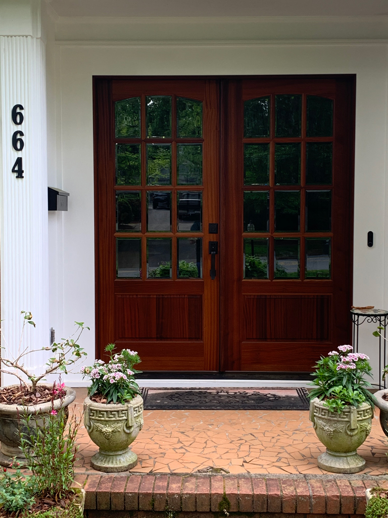 Double wooden glass-pane front doors with planters