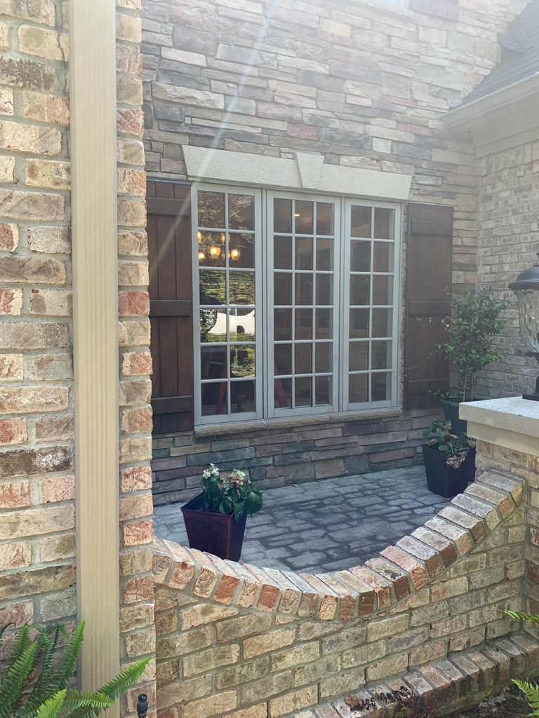 Brick exterior courtyard with shuttered window