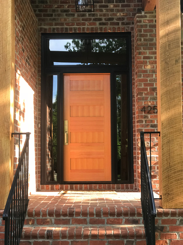 Modern wooden front door with brick steps