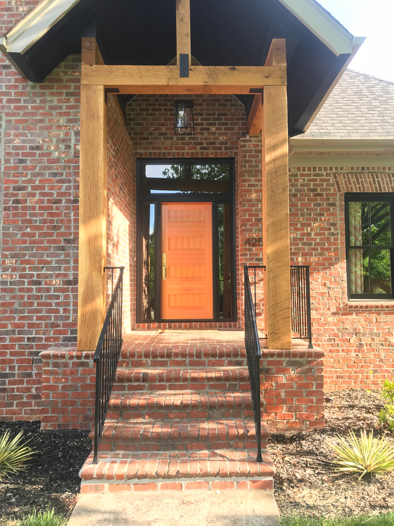 Brick house entrance with orange front door