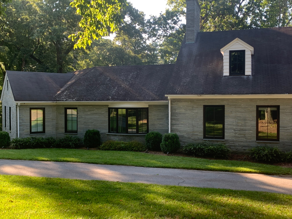 Stone ranch house with dormer and driveway