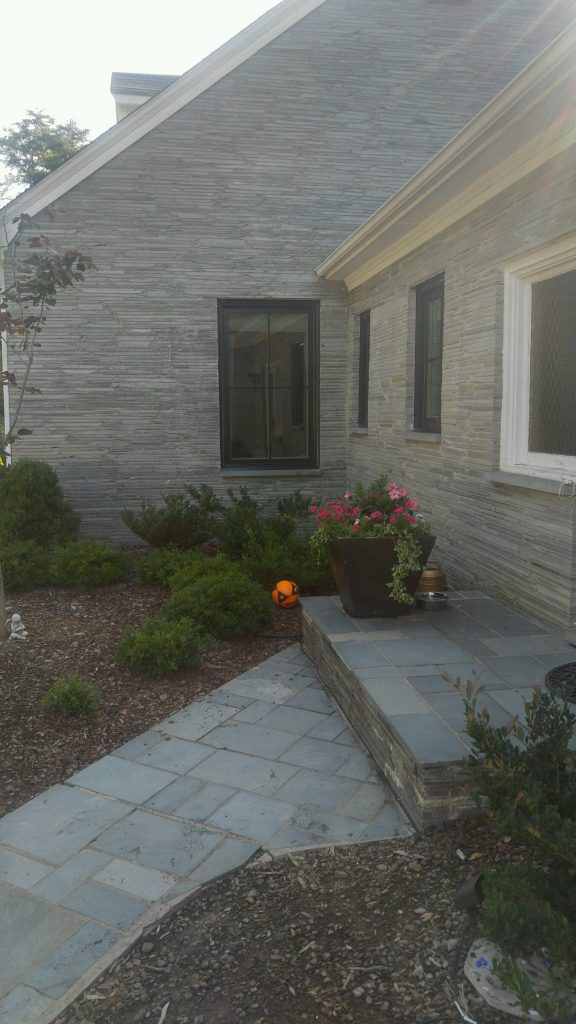 Gray stone house walkway with potted plants