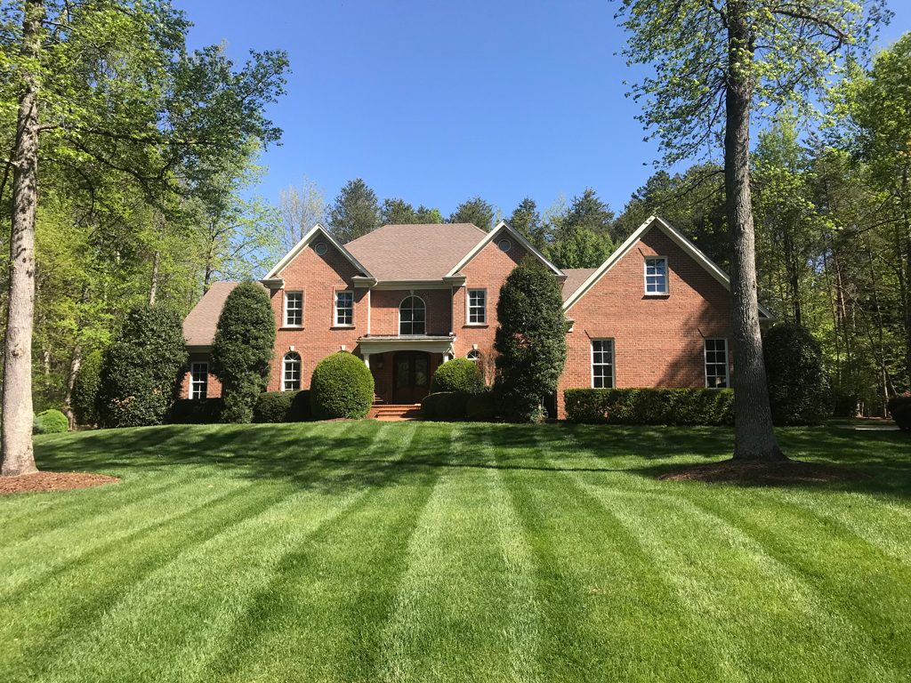 Brick house with manicured striped lawn