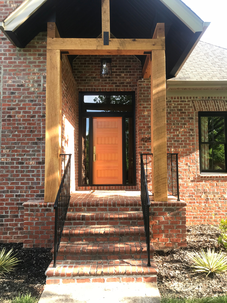 Brick house front entrance with orange door