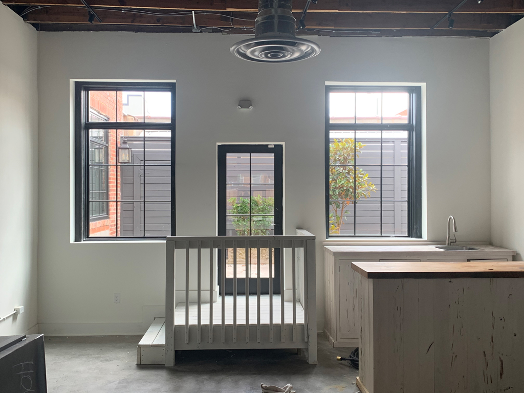 Bright industrial loft interior with windows, kitchenette