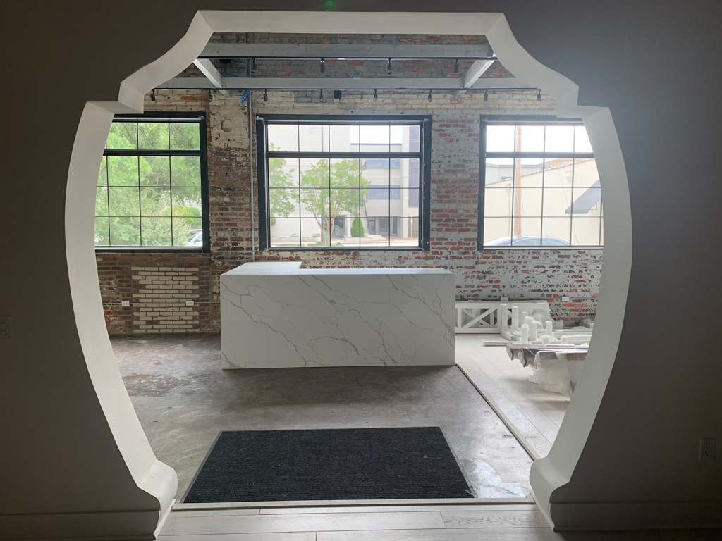 Arched opening to room with marble island