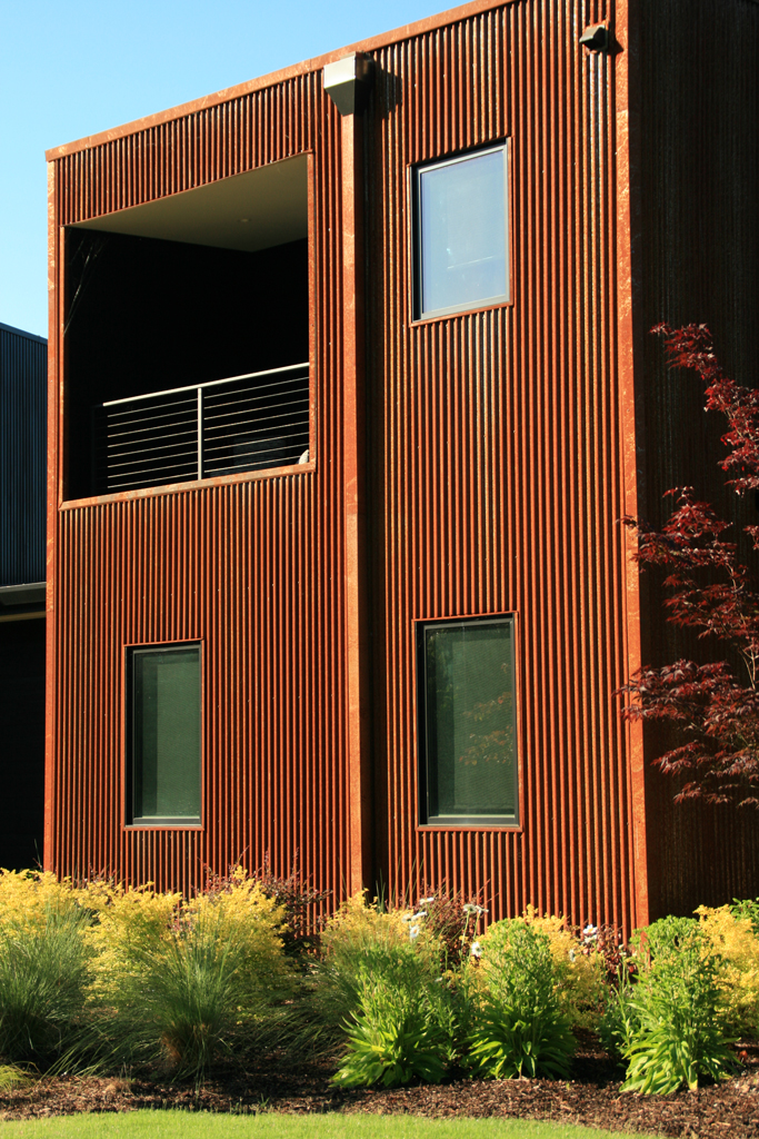 Rust-colored corrugated metal building with balcony