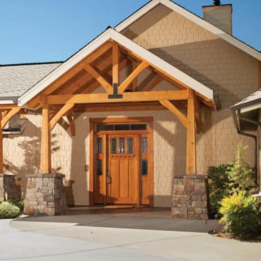 Wooden front door with timber porch, stone pillars