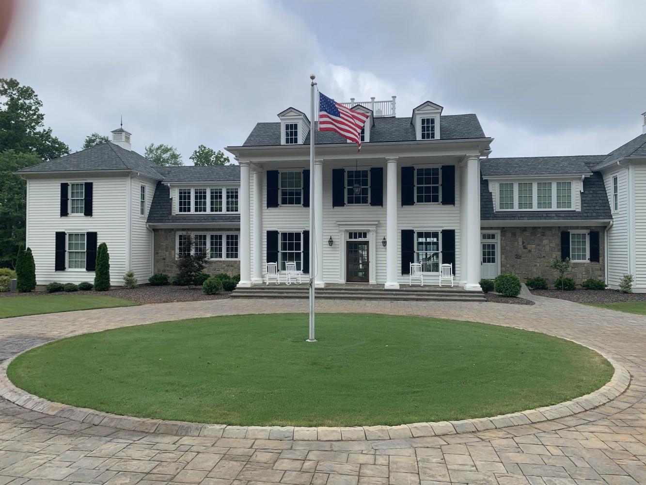 Colonial white mansion with circular driveway and flag