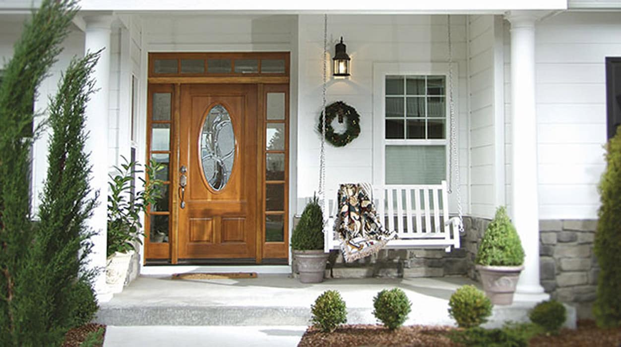 White porch with wooden oval glass door